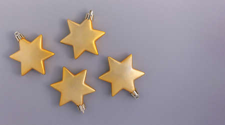 Christmas background of golden stars on a gray background. Ornament for Christmas and New Year