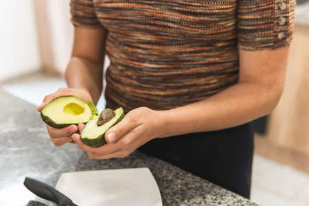 Close-up of a woman's hands opening an avocado