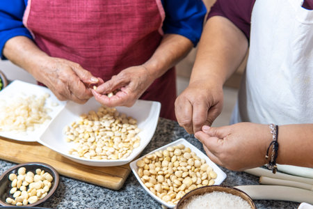 Close-up of the hands of two women peeling to prepare fanescaの写真素材