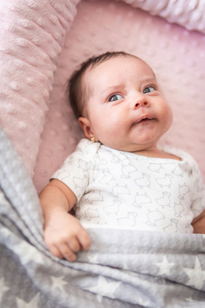 Baby looking to the side lying in his cribの写真素材