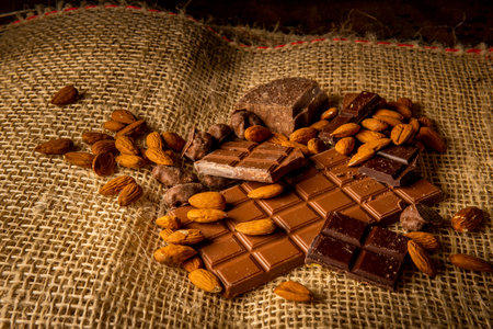Horizontal photograph of variety of chocolates with almonds on a jute bagの写真素材