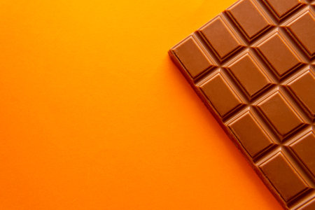 Dark chocolate isolated on yellow background with copy spaceの写真素材