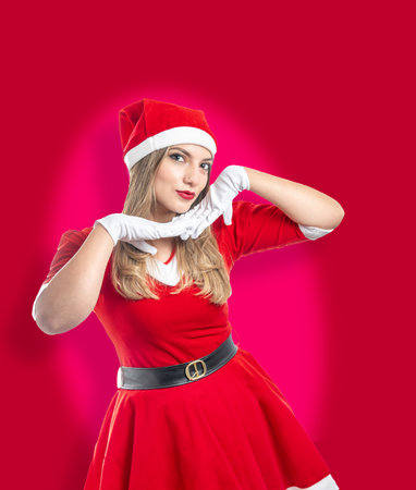 Young Santa Claus looking at camera with a funny gesture isolated on red backgroundの写真素材