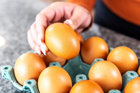 closeup of a hand taking an egg for a recipeの写真素材