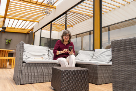 Senior woman doing business or browsing on her cell phone outdoorsの写真素材