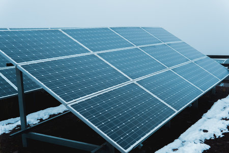 Solar panels capturing sunlight in a snowy mountain environment, generating sustainable and...