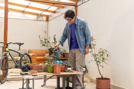 Person is watering potted plants on a patio, engaging in a relaxing gardening hobby