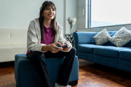 Young woman smiling while holding a controller and playing video games in living room