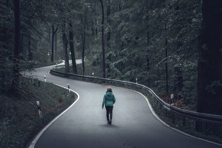 Woman Walking along the forest streetの写真素材