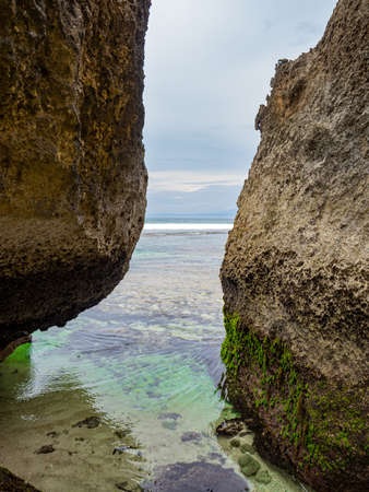 Uluwatu beach view Bali Indonesia with crystal clear water between the rocksの写真素材