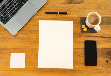 Table Top desk view with pencil a plant, coffee, workspace, mobile display and laptop businessの写真素材