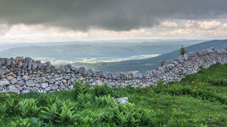 Mountain view with bad weather. the sky was dark above the stone wallの写真素材