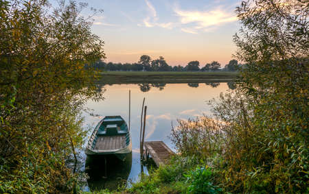 Colorful Sunset on the river with wooden Boat on the riverの写真素材