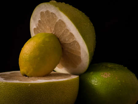 citrus fruit composition on black background. lemon, green grapefruit