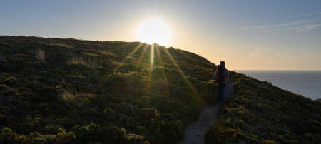 Hiker on the cliff during the sunset, in brittany Erquyの写真素材