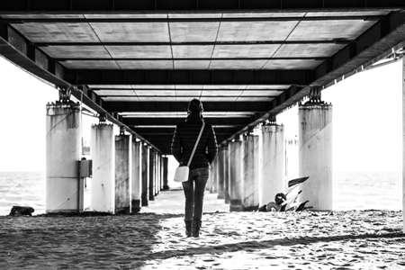 a woman walking down a pier to infinity