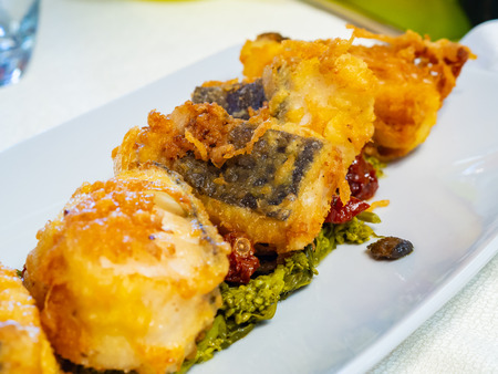 tasty pieces of crispy fried cod, appetizing, seasoned with broccoli cooked in a pan and dried...