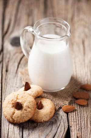 Almond biscuits and a jar of milkの写真素材