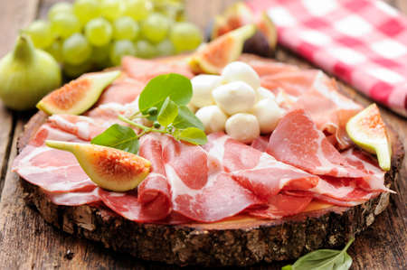plate of prosciutto ham mozzarella and fresh figsの写真素材