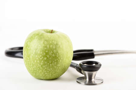 stethoscope and green apple isolated on the white backgroundの写真素材