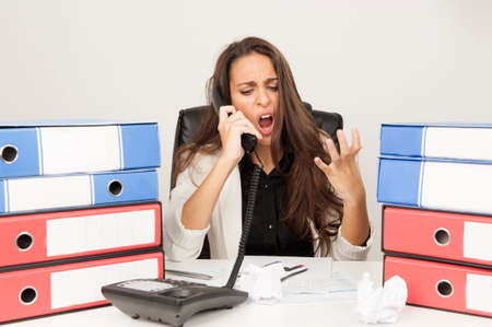 Businesswoman stressed at work while she is on the phoneの写真素材