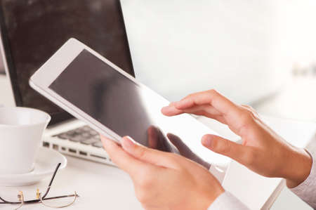 Hand of a woman using a digital tablet