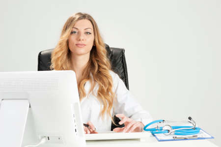 Attractive female doctor sitting on her deskの写真素材