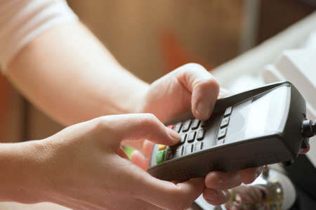 Person entering pin code at credit card reader