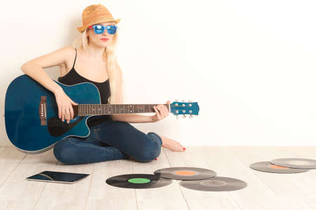 Girl musician sitting on a floor with acoustic guitarの写真素材
