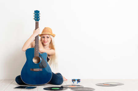 Girl musician sitting on a floor with acoustic guitarの写真素材