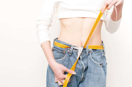 Slim girl in big jeans isolated on white