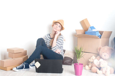 young woman sitting on the floor in a new homeの写真素材