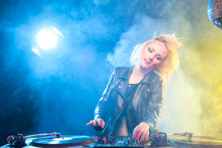 Cute dj woman having fun playing music on vinyl record deckの写真素材