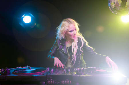 Cute dj woman having fun playing music on vinyl record deckの写真素材