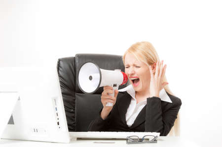 business concept - strict businesswoman shouting in megaphone in officeの写真素材