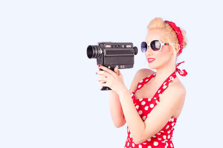 Pin-up girl holding a vintage 8mm cameraの写真素材