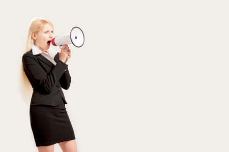 Businesswoman shouting into a megaphone isolated on whiteの写真素材