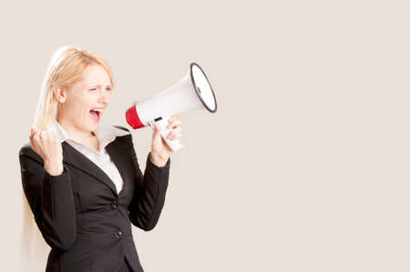 Businesswoman standing with megaphone isolated on a white background. Looking at cameraの写真素材