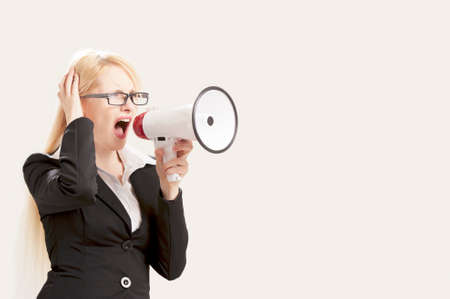 Business woman with megaphone yelling and screaming isolated on white backgroundの写真素材