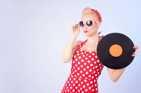 Pin-up girl in vintage dress holding a vinyl recordの写真素材