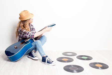 Girl musician sitting on a floor with acoustic guitarの写真素材