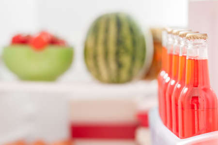 Open fridge with bottles of alcoholic drinks