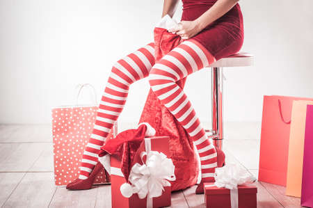 Sexy Santa woman legs. Christmas shopping concept. Xmas gift boxの写真素材