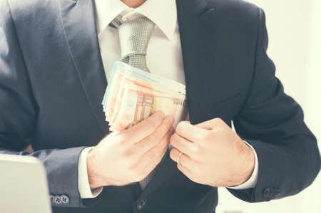 Businessman putting money in his pocketの写真素材