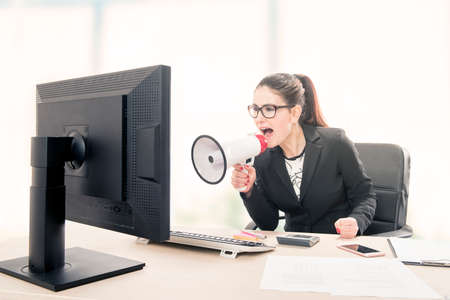 Businesswoman yelling through a megaphoneの写真素材