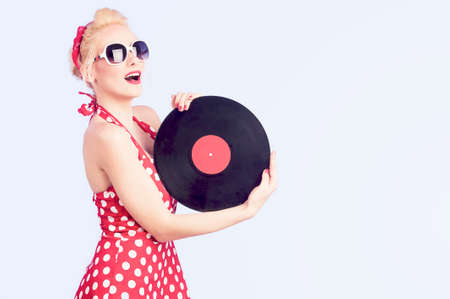 pin-up girl in vintage dress holding a vinyl records