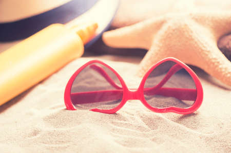 Starfish with glasses on a beach sandの写真素材