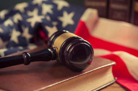 Wooden Gavel with American Flag on a wooden tableの写真素材