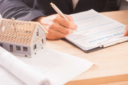 Businessman signing a mortgage  contract  of a sale for a new house