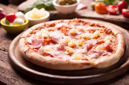 Wood Fired Gourmet pizza with a topping of Ham and Pineappleの写真素材